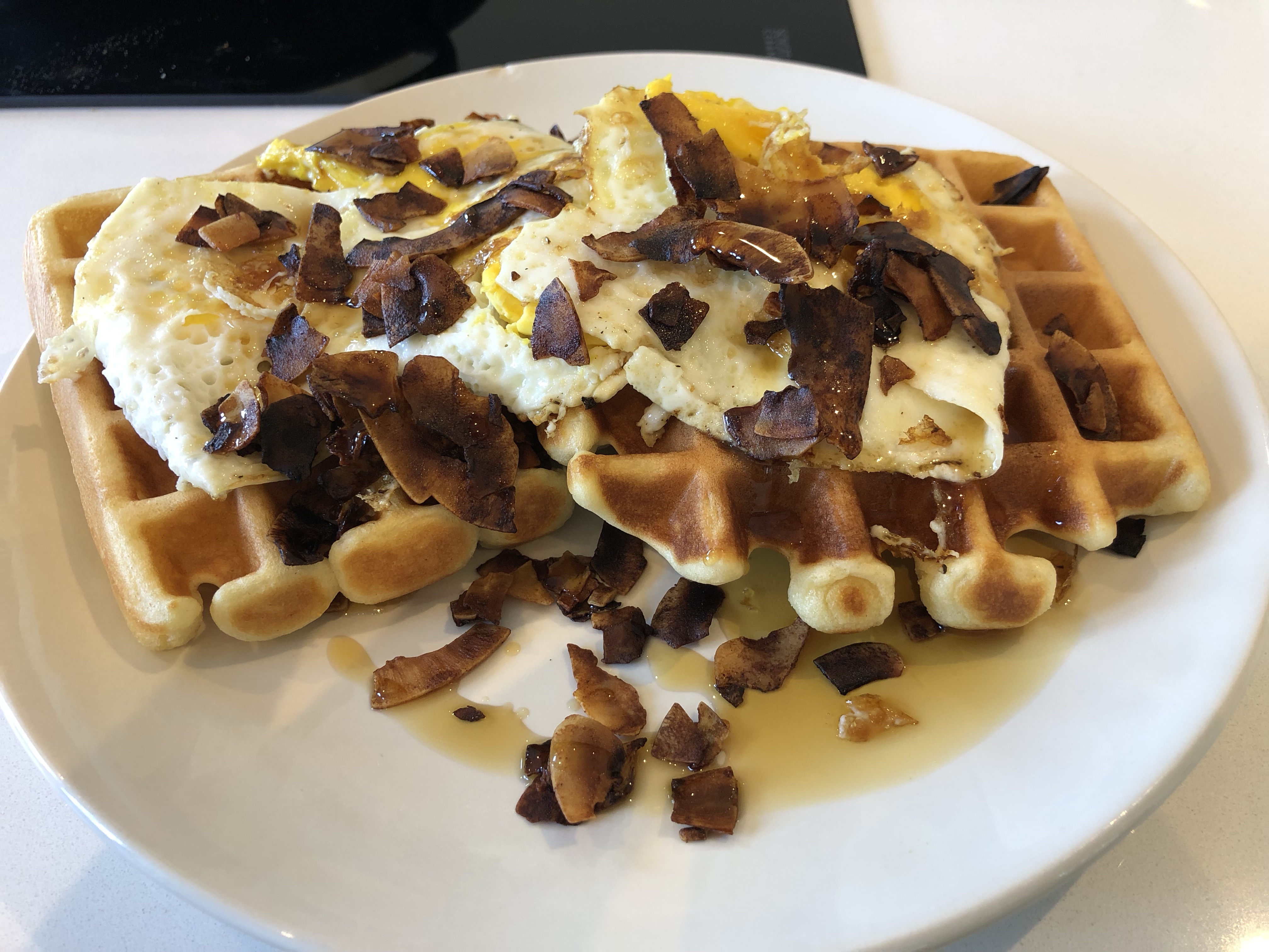 Waffles with eggs and coconut bacon on top.