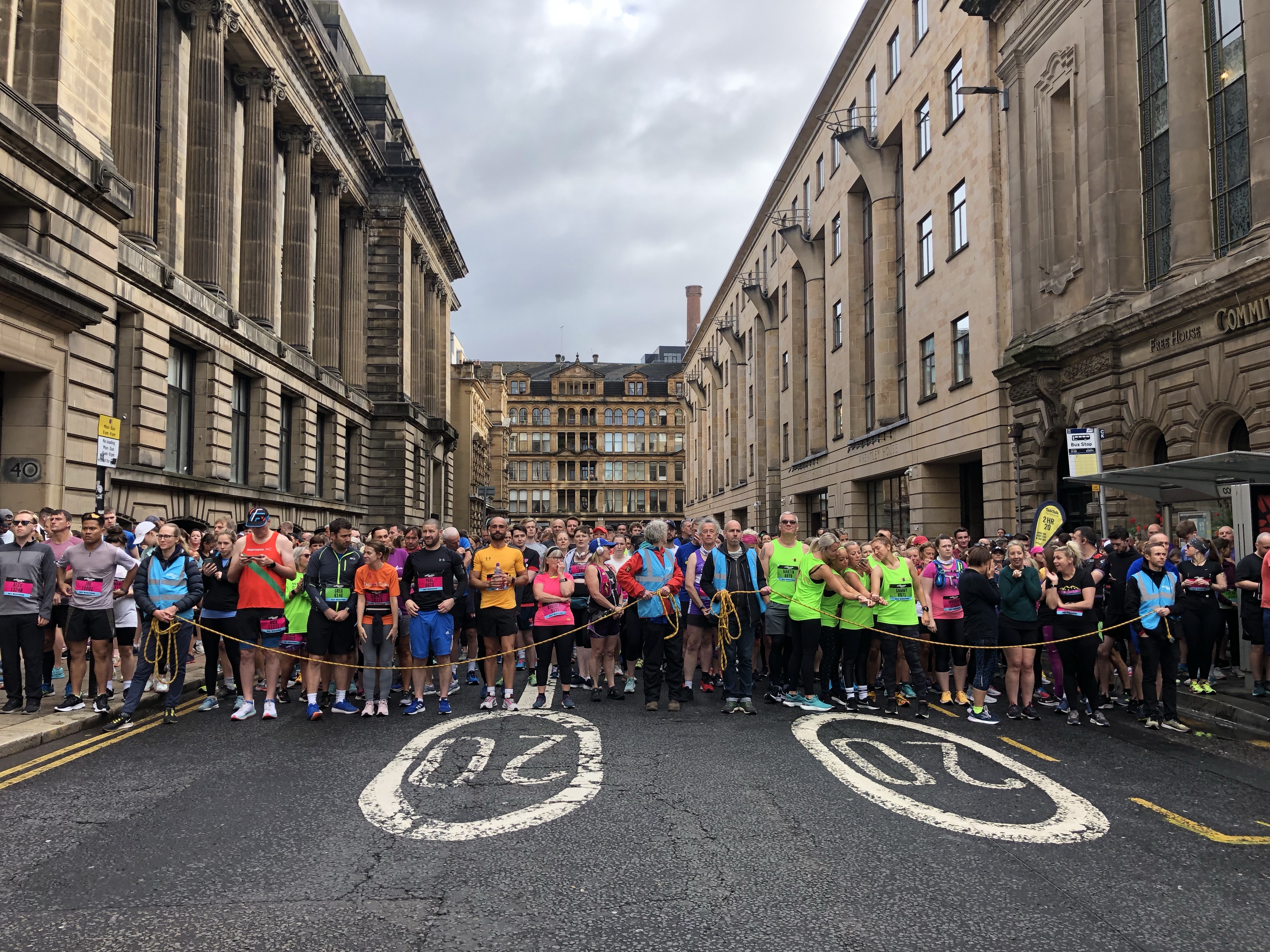 Runners standing behind a starting line on the streets in Glasgow.